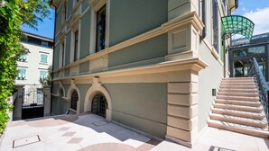 Un bâtiment de style architectural classique, doté d’un grand escalier et d’une entrée protégée par un portail.