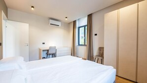 Une chambre d’hôtel moderne avec un grand lit, un bureau et une armoire.