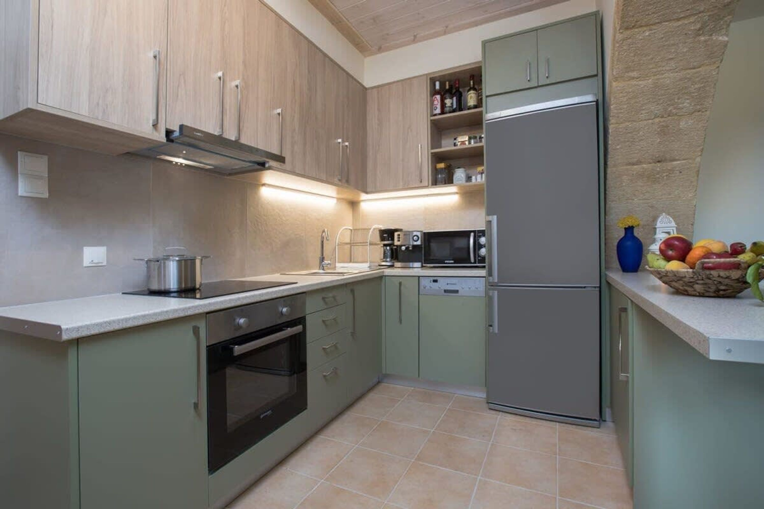 A kitchen with a stainless steel refrigerator, a microwave, a stove, and a sink.