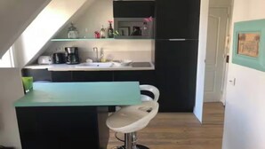 A compact kitchen with a sink, a coffee maker, and a refrigerator. - BEAUTIFUL 19M² STUDIO IN ODÉON & SAINT-GERMAIN-DES-PRÉS WITH TWO BALCONIES (Paris)