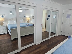 Ein Schlafzimmer mit Bett, Nachttisch, Nachttischlampe und Deckenventilator.