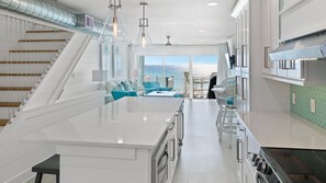 A modern kitchen with white cabinetry, a large island, and a view to the outside. - 12B - 2BR $700+ in freebies incl golf, On Beach (Miramar Beach)