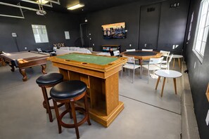A billiards room with a pool table, stools, and a green felt table. - Luxury Glamping Estate with Hot Tub Near San Jose (Gilroy)