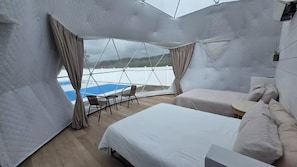Ein zeltartiges Zimmer mit einem Bett, einem kleinen Tisch und einem Stuhl.
