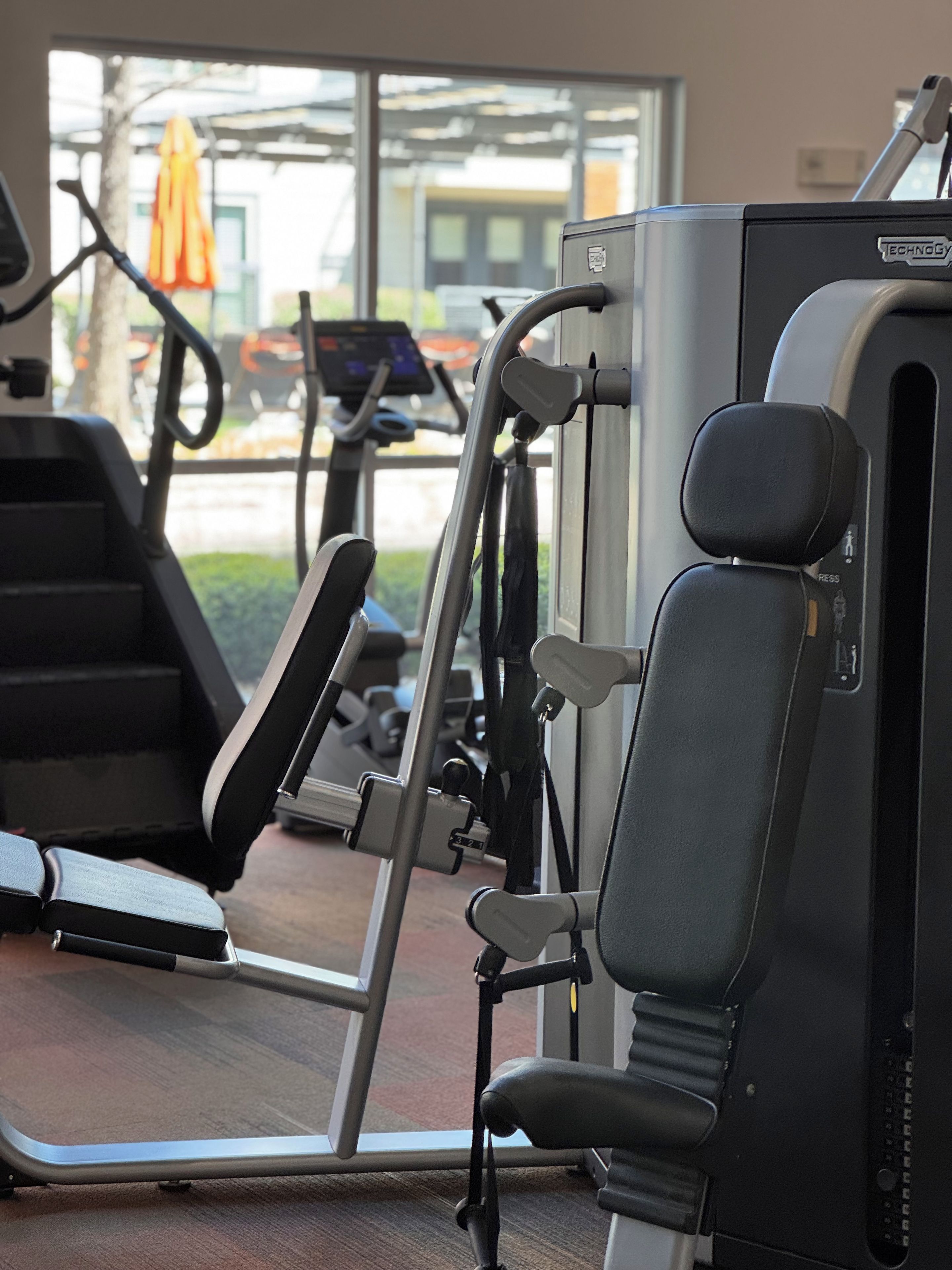 A gym with exercise equipment, including a treadmill and a weight machine.