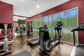 A gym with cardio machines, weight training equipment, and a TV screen. - 8 guests /4 beds /3 baths /Lucaya Village (13-108) (Kissimmee)