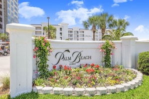 Naamplaatje voor Palm Beach met een aangelegde tuin ervoor.