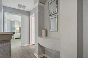 A hallway with a white wall, a white door, and a white dresser with drawers. - Epic Star Wars + Harry Potter Rooms Near Disney (Kissimmee)