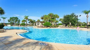 A swimming pool with a 4 ft depth marker, surrounded by palm trees and lounge chairs. - Epic Star Wars + Harry Potter Rooms Near Disney (Kissimmee)