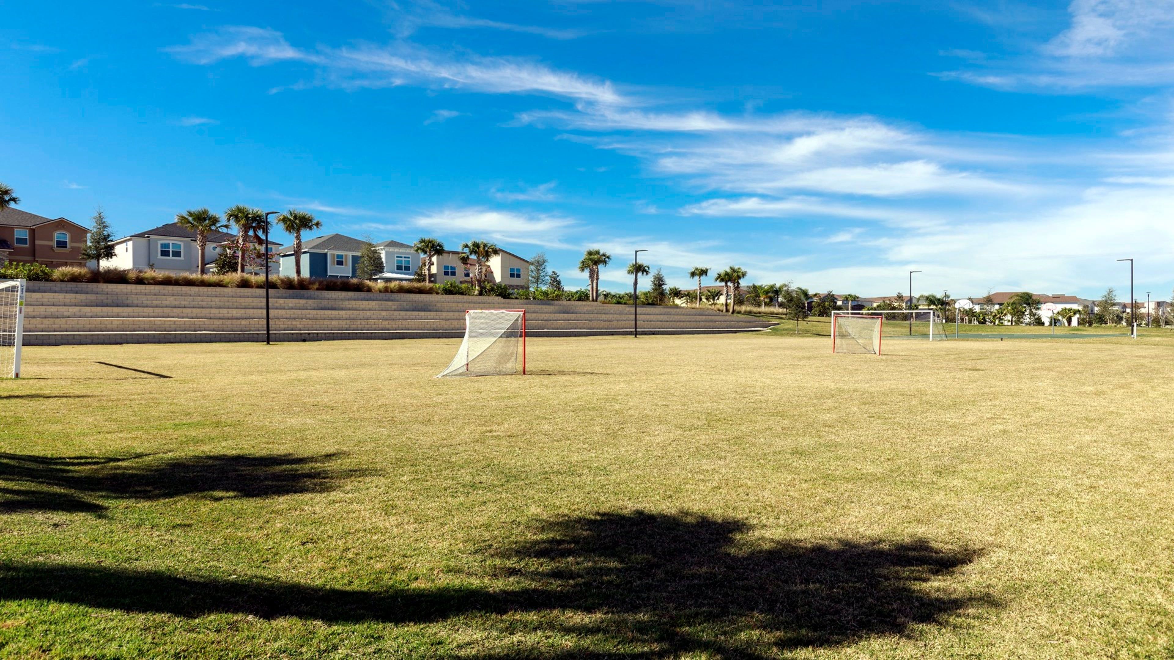 A soccer field with goalposts and a clear sky.