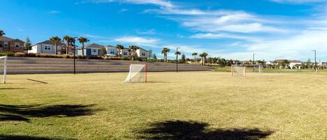 A soccer field with goalposts and a clear sky.