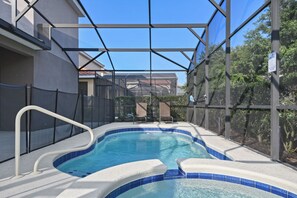 An indoor swimming pool with a clear view of the surrounding area, including a covered patio and a fence. - Game Room, Pool & Mickey-themed Retreat (Davenport)