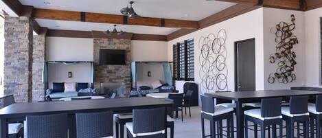 Un amplio espacio interior con una larga mesa de comedor, múltiples sillas, chimenea y una pared de piedra.