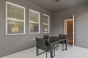 A room with a table and chairs, a door, and three windows with blinds. - Game Room, Pool & Mickey-themed Retreat (Davenport)