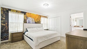 A bedroom with a bed, nightstands, a dresser, a large window with curtains, and a wall mural. - 4BR w Screened Pool & Resort Access Near Parks (Kissimmee)