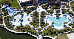 An aerial view of a resort with a central pool, a water slide, and multiple lounge areas. - Spider-man Gamer Paradise + Themed Bedrooms (Kissimmee)