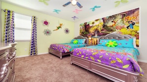 Ein Schlafzimmer mit zwei Betten, einem Schminktisch und einem großen Blumenbild an der Wand.