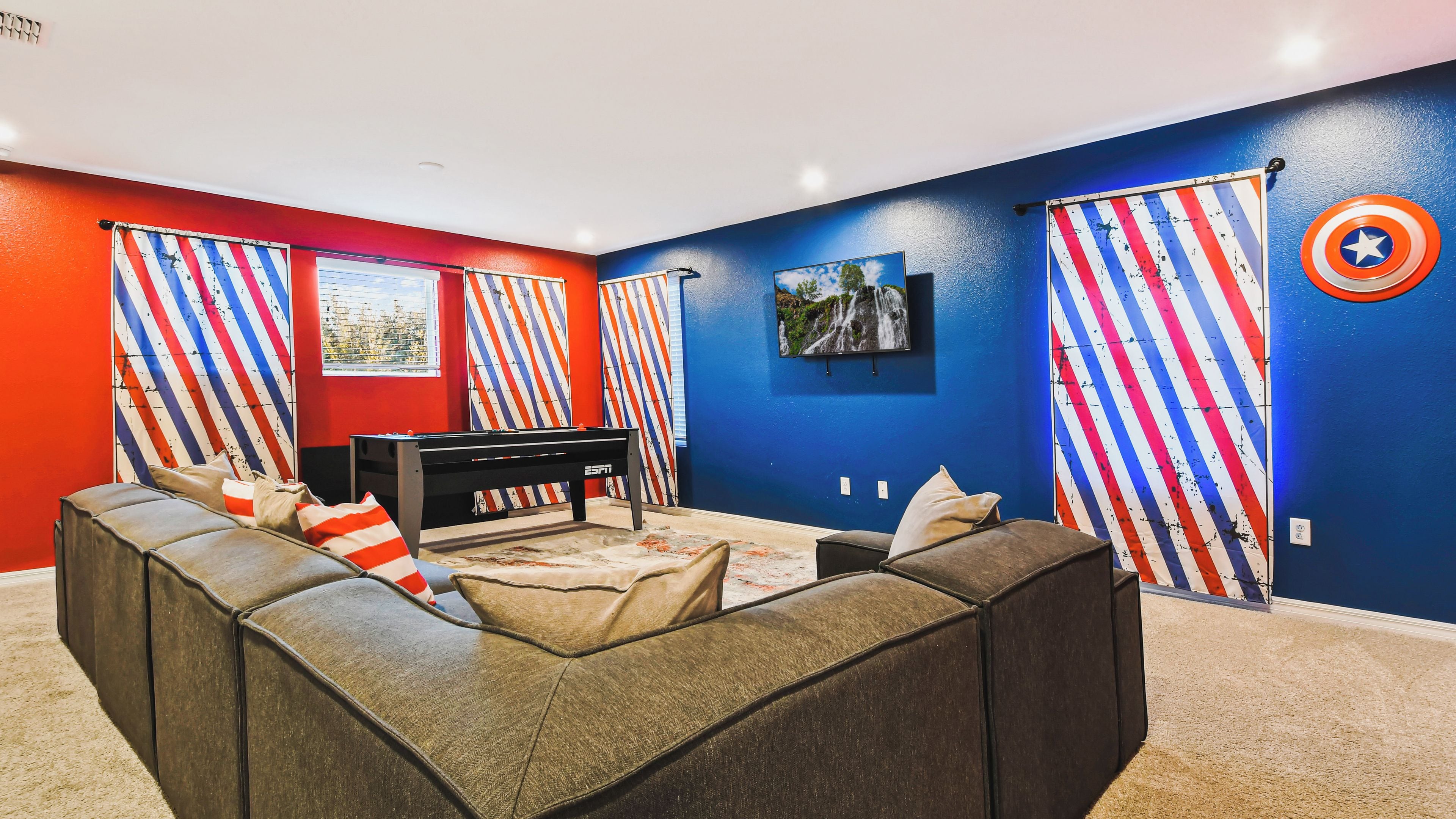 Ein Zimmer mit Billardtisch, einer Couch und gestreiften Vorhängen.