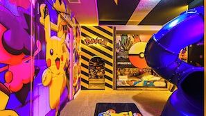 A room with vibrant Pokemon-themed decor, including wall art and a large poster. - Epic Game Loft & Space-themed Theater Experience (Kissimmee)