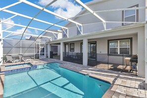 A swimming pool with a glass enclosure, outdoor furniture, and a patio area. - Resort Villa w/ Game Room & Disney Murals (Davenport)