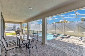 A covered patio area with a pool, outdoor seating, and a grill. - Resort Villa w/ Game Room & Disney Murals (Davenport)