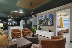A modern living room with a pool table, leather sofas, a large TV, and a bar area. - Top Gun Bunks + Luxe Bar & Game Room (Davenport)