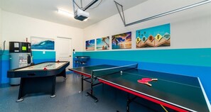 Ein Raum mit Tischfußball, Pongtisch und Projektionsfläche.