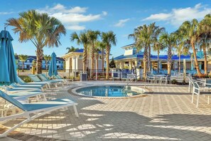 A resort pool area with lounge chairs, palm trees, and a pool. - Windsor Island Retreat 7BR Pool Home (Davenport)