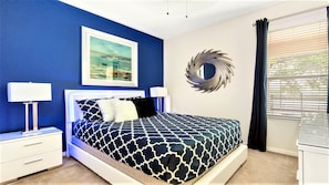 A bedroom with a bed, nightstands, a wall-mounted mirror, and a window with blinds. - Game Room, Pool & Themed Bedrooms/close2disney! (Kissimmee)