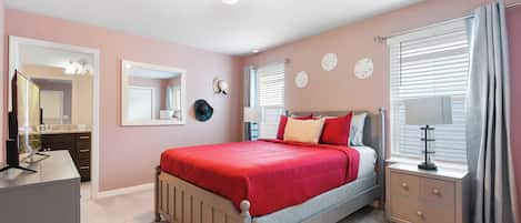 Un dormitorio con cama, mesitas de noche, cómoda, espejo y ventana con cortinas.