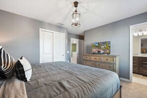 A bedroom with a bed, a dresser, a television, and a door. - 8BR @ Windsor Island/star Wars Gameroom/themed BR (Davenport)