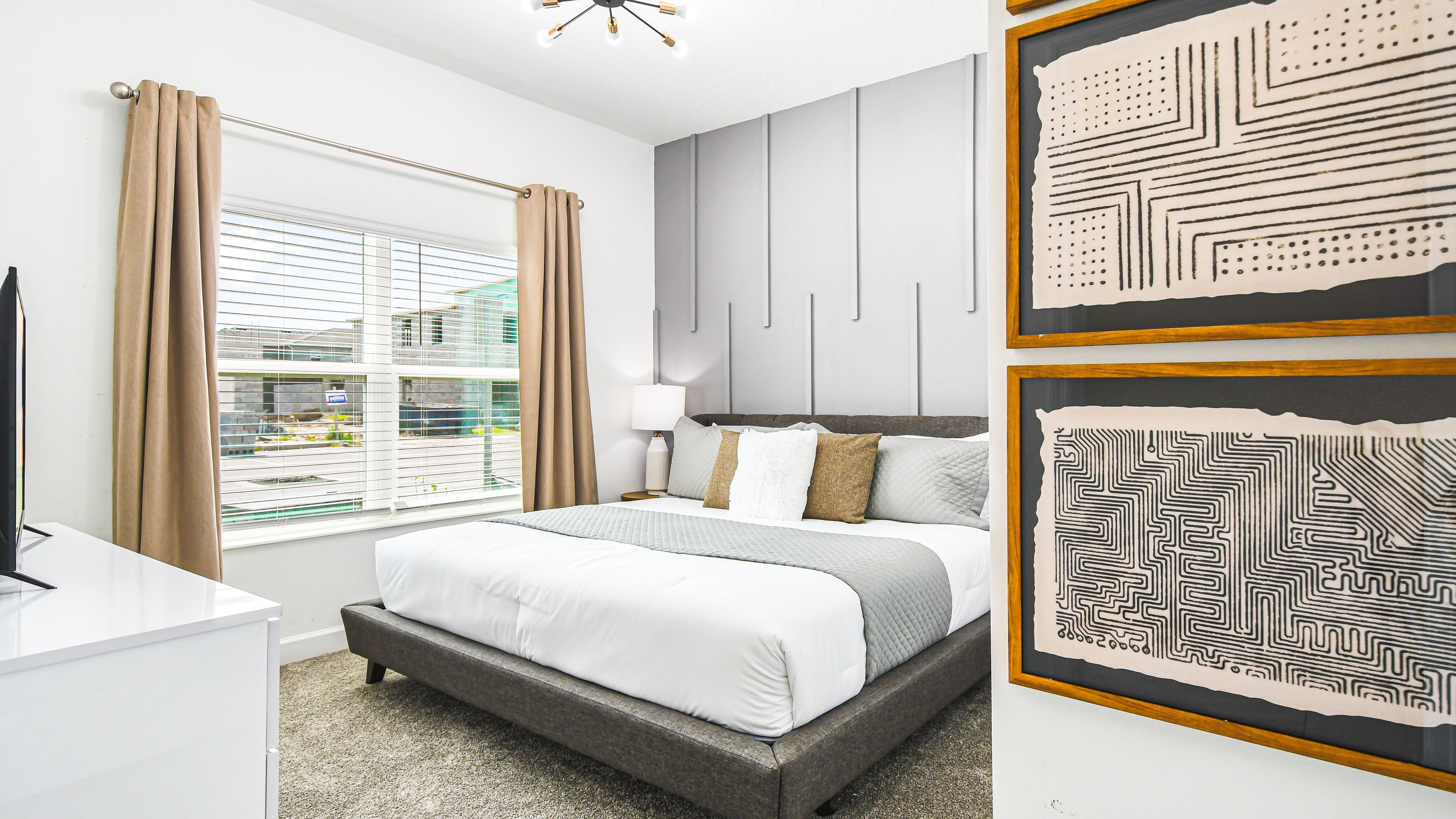 A modern bedroom with a bed, bedside table, and a window with curtains.