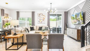 A modern living room with a sofa, chairs, a coffee table, and a TV. - SW & Frozen Rooms, Pool, Spa, 3 King Beds (Kissimmee)
