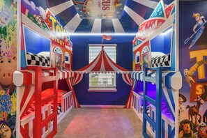 A children's playroom with colorful murals, bunk beds, and a circus-themed tent. - Minion Themedprivate Pool Game Room & Green Views (Davenport)