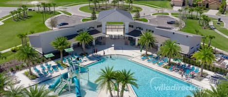 Ein Resort mit einem zentral gelegenen Pool, Palmen und einem modernen Gebäudebau.