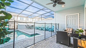 A covered patio with a pool, outdoor furniture, and a ceiling fan. - Vibrant Villa With Tropical Mural & Fun Bunk Beds (Davenport)