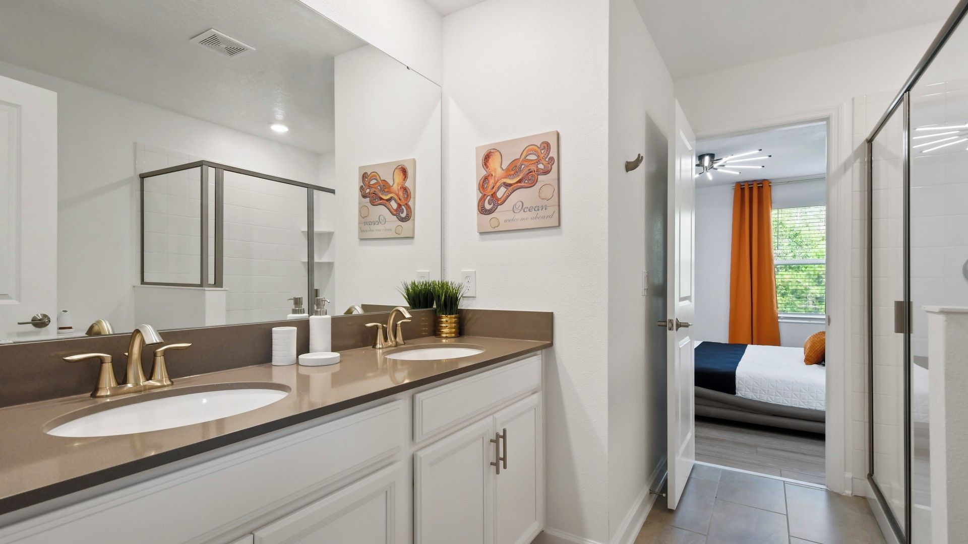 Un bagno moderno con doppio lavabo, uno specchio grande e un'opera d'arte appesa al muro.