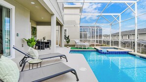 Un espace piscine comprenant des chaises longues, une table et une petite piscine.
