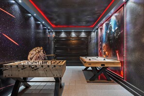 A room with two foosball tables, a space-themed mural, and a Star Wars-themed wall. - Family Retreat w/ Circus Lounge & Game Room (Davenport)