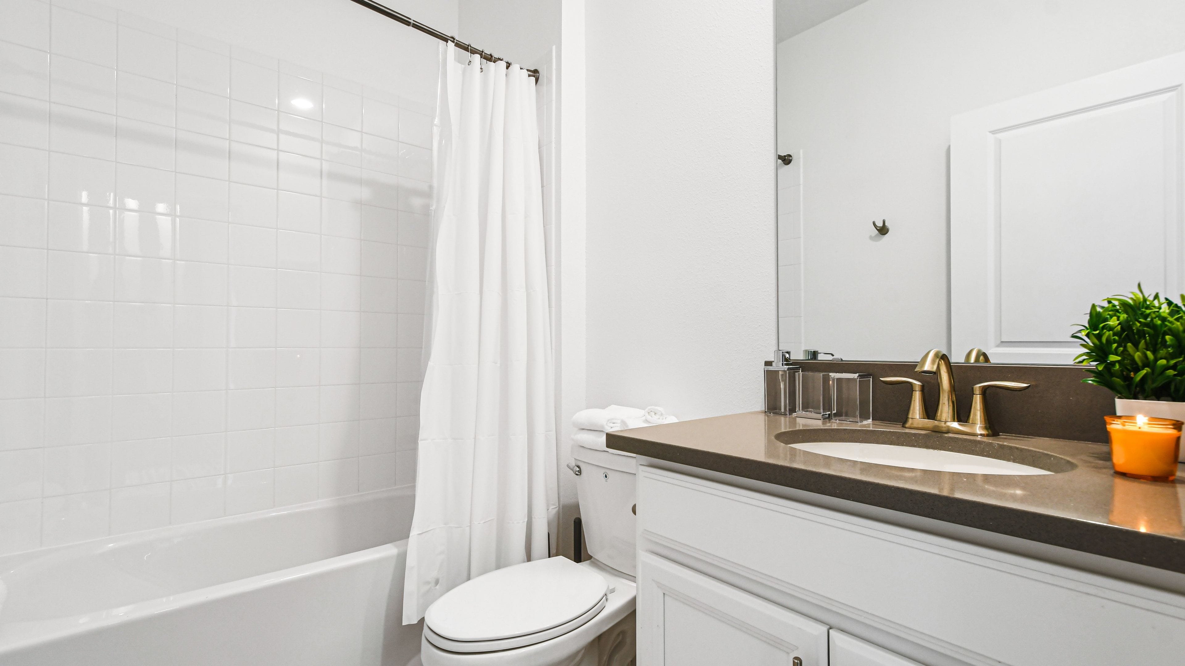 A modern bathroom with a bathtub, toilet, and sink.