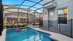 An indoor swimming pool with clear glass walls, a hot tub, and a patio area with plants. - Hogwarts to Arendelle: Themed Magic Near Disney (Kissimmee)