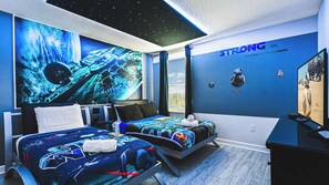 A bedroom with a space-themed mural, a bed with a galaxy-patterned bedspread, and a wall with a 'STRONG' motivational quote. - Harry Potter, Mickey & Space Rooms + Theater! (Davenport)