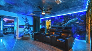 A room with a ceiling fan, a large aquarium wall, and several leather chairs. - Harry Potter, Mickey & Space Rooms + Theater! (Davenport)