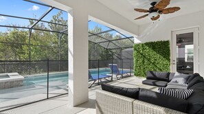 A covered outdoor area with a pool, lounge chairs, and a ceiling fan. - Minions, Star Wars, & Frozen-themed Family Retreat (Kissimmee)