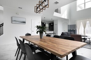Ein stilvoller Essbereich mit Holztisch, schwarzen Stühlen und einem Blumentopf.