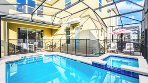 An indoor swimming pool with a glass enclosure, surrounded by lounge chairs and a patio area. - Harry Potter~frozen Room 5BR w Game Room, Disney! (Kissimmee)