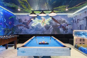 A pool table with a colorful ball rack, a foosball table, and a mural of a celestial scene with a figure on a starfish. - Avatar Game Room + Harry Potter BR w/ Pool~spa (Kissimmee)