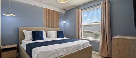 A bedroom with a bed, bedside tables, a wardrobe, a window with curtains, and a ceiling light fixture.