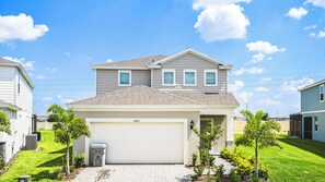 A two-story residential house with a garage, numbered 3305, surrounded by a well-maintained lawn and small trees. - Bright Minions & Hogwarts Escape Close to Disney (Davenport)