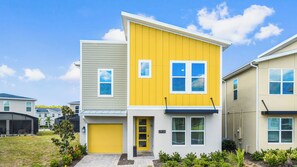 A modern two-story residential building with a yellow front door, a garage, and a number '2936' sign. - Disney! Themed Rooms, Private Pool, Resort Access! (Kissimmee)